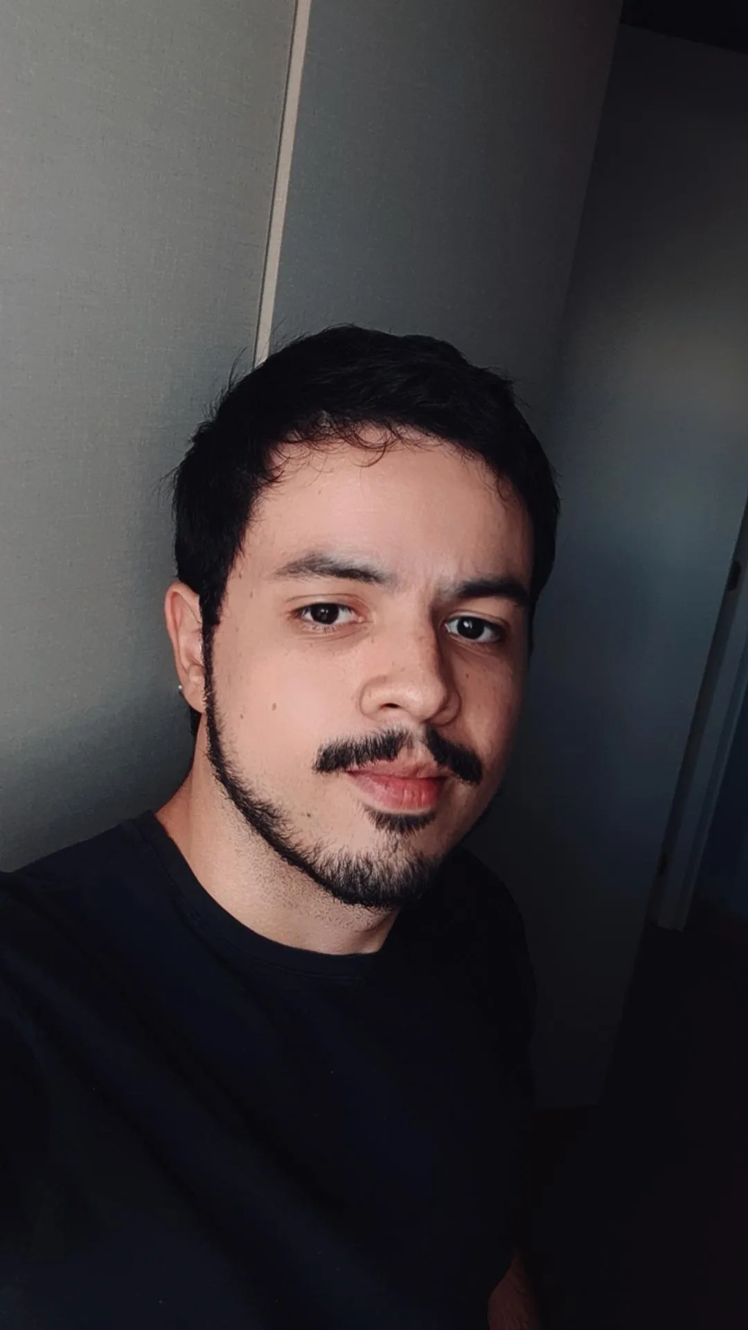 Selfie em preto e branco do Henrique usando camiseta preta.